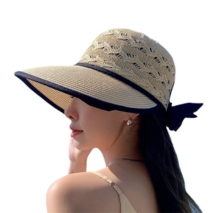 Women's foldable straw sun hat with black bow and breathable hollow design in beige