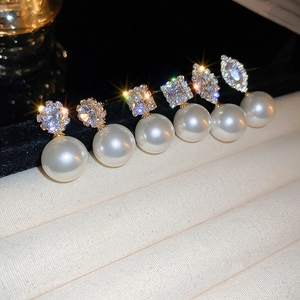 Macro shot of geometric pearl earrings with shimmering cubic zirconia and gold plating