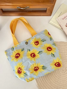 Light blue sunflower canvas tote bag with yellow woven handles and metal snap button