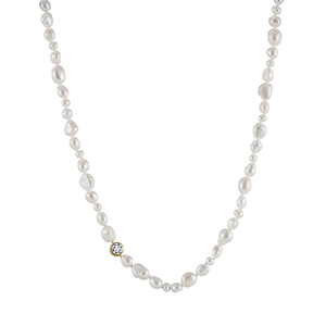 Detailed macro shot of baroque pearl necklace featuring a gold-rimmed sparkling gemstone