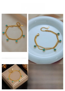 Detail of double-layered gold snake chain bracelet with five round turquoise stones
