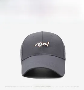 Close-up of dark grey baseball cap with 'on!' embroidery and breathable mesh texture