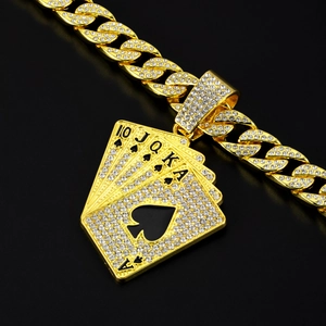 Close-up of iced out golden poker ace pendant with cuban link chain and crystals
