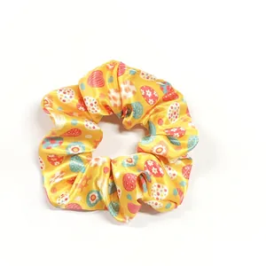 Macro view of bright yellow Easter scrunchie with colorful floral and egg patterns