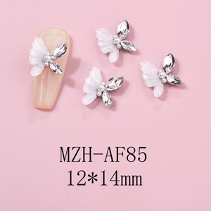Macro shot of 12x14mm 3D white resin butterfly nail charms with pearl and rhinestone accents