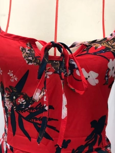 Detail of red floral dress neckline with tie-up bow on white mannequin stand