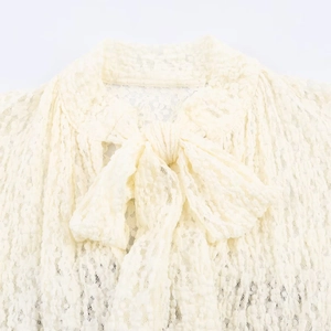 Chic cream jacquard lace romper featuring a textured bow tie neckline detail