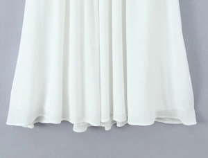 Detailed view showing the flowing hem and textured fabric of the white maxi dress