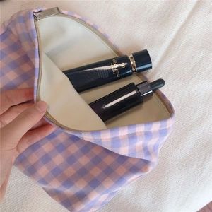 Close-up of checkered canvas cosmetic bag with metal zipper and soft interior lining
