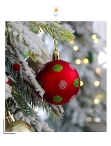 Nahaufnahme einer roten Weihnachtskugel mit Glitzerpunkten auf verschneiten Tannenzweigen