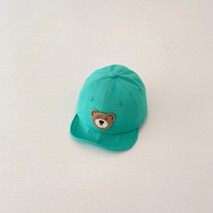 Detail view of mint green baby baseball cap featuring a cute knitted bear patch