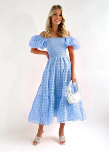 Detail of off-shoulder light blue tiered maxi dress with plaid texture and puff sleeves