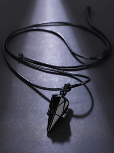Macro detail of obsidian pendulum pendant with black woven mesh on a textured dark surface