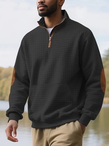 Detail der Waffelstruktur und braunen Ellbogen-Patches am schwarzen Herren-Sweatshirt