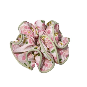 Floral print scrunchie in pink and green with light green trim for bun hairstyles