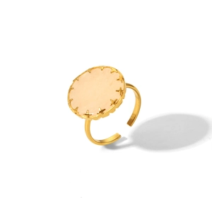 Vue détaillée d'une bague dorée avec pierre rose ronde et bordure étoilée