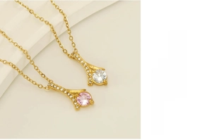 Detail view of gold-plated necklaces with white and pink cubic zirconia pendants