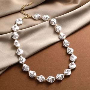 Close-up of baroque pearls with golden spacers on satin fabric for a luxury texture
