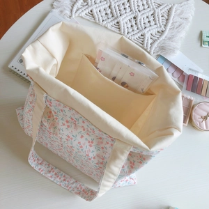 Macro view of floral canvas tote bag interior showing beige lining and inner pocket