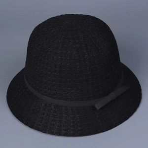 Detail of black straw bucket hat with fine woven texture and matching silk bow ribbon