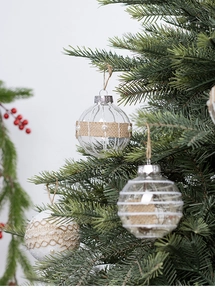 Detail of clear and white rustic Christmas ornaments with lace and pearls on tree