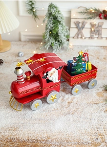 Detail of Christmas iron train with Santa Claus, mini tree and gift box in warm festive setting