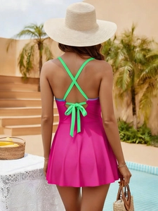 Détail des bretelles croisées vert néon et du maillot de bain rose avec nœud
