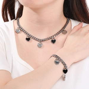 Détail du set de chaînes cubaines plaquées or 18K avec pendentifs cœur noir et argent