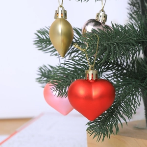 Set of electroplated heart and teardrop shaped Christmas ornaments on tree branches