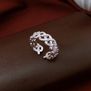 Détail macro d'une bague tressée argentée avec zircons pavés et accents floraux