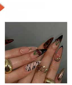 Detail of almond nails featuring 3D cherry accents and black zebra print patterns