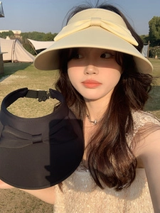 Detail of adjustable sun hat with large bow decoration on outdoor summer grass