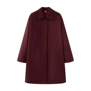 Detail of burgundy long coat showing smooth fabric texture and hidden button placket