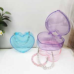Detail von herzförmigen Perlen-Aufbewahrungsboxen in Blau, Lila, Transparent und Rosa