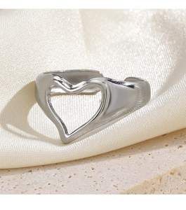 Polished silver heart open ring displayed on silk and stone background textures