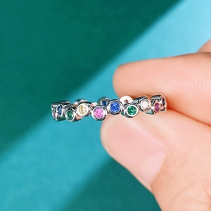 Minimalist rainbow gemstone ring with colorful circular cut stones in silver band