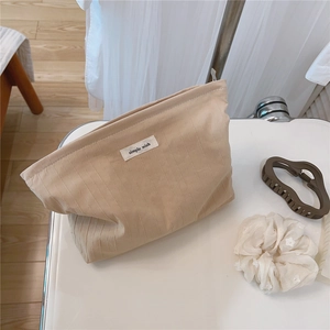 Detailed view of striped cotton makeup bag with simple wish label on white tray