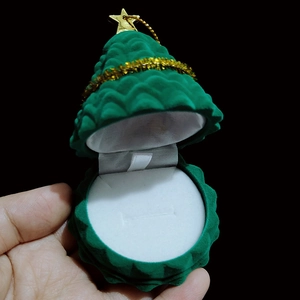 Detail of green velvet Christmas tree jewelry box with gold star and ring slot