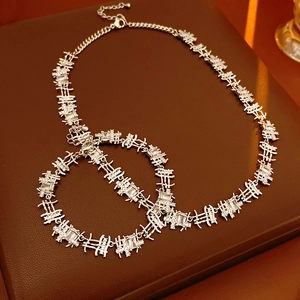 Close-up of silver zircon necklace and bracelet set with unique link structure on leather