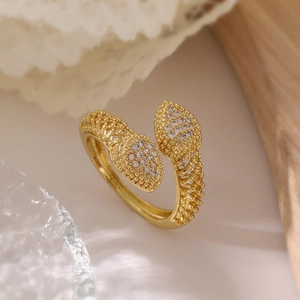 Macro shot of gold-plated leaf ring featuring sparkling zircon pavé and textured open band