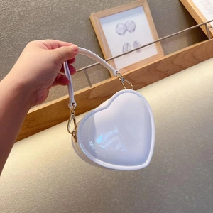 Detailed view of a mini white heart-shaped jelly bag with gold hardware and smooth finish