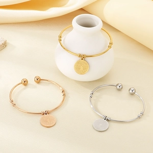 Three minimalist stainless steel open bangles in gold, rose gold and silver with cross charms