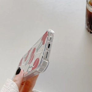 Close-up of transparent iPhone case with red cherry pattern and printed text detail