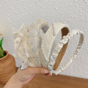 Detailed macro view showing diverse pearl embellishments and delicate lace flower headbands