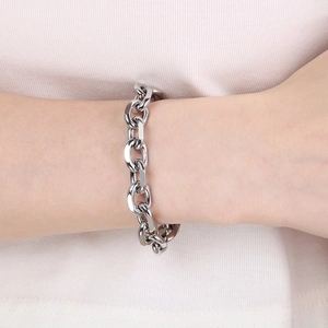 Close-up of polished stainless steel Cuban link bracelet with OT clasp on a wrist