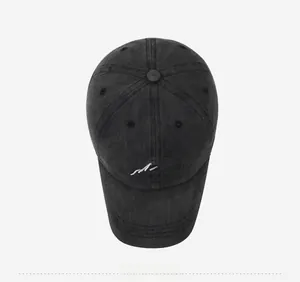 Top view of black washed cotton baseball cap with minimalist peak embroidery detail