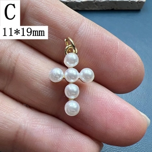 Macro detail of a 11x19mm gold pearl cross pendant for DIY jewelry making