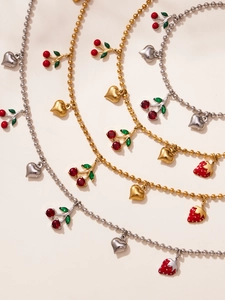 Détail des colliers avec pendentifs cerise et cœur en finitions dorée et argentée