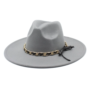 Detail of grey wool fedora hat featuring a gold chain buckle and elegant bow trim