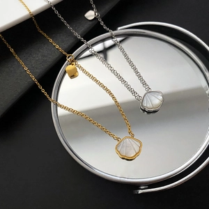 Elegant gold and silver shell pendants with mother of pearl on sleek mirror surface